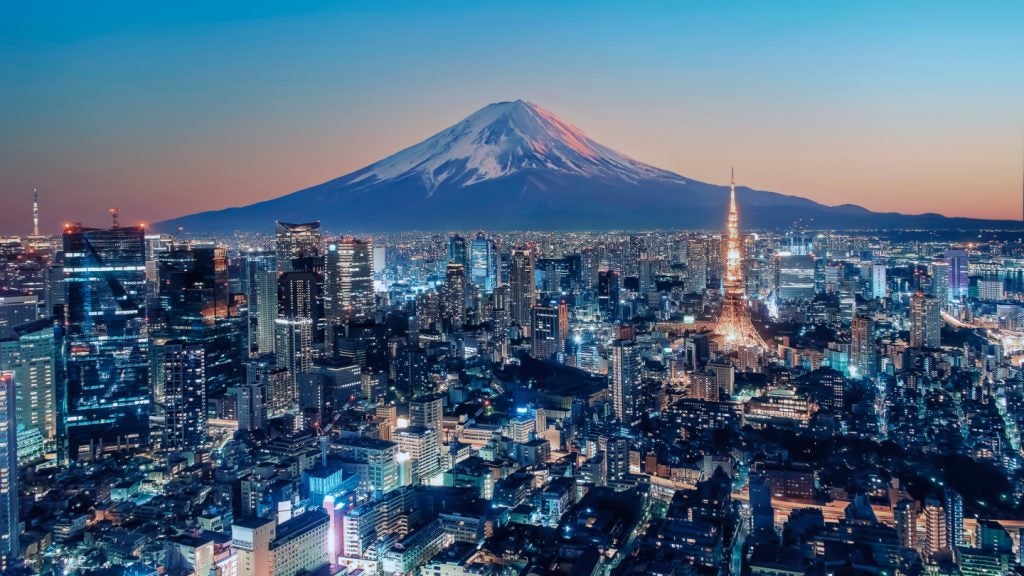 Tokyo City viewed from high up at sunset with Mount Fuji in the background.